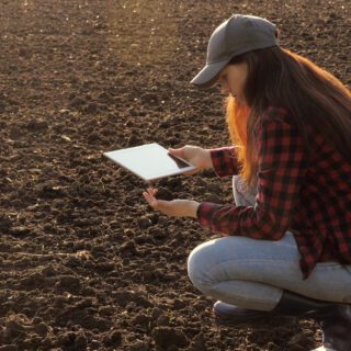 Woman,Farmer,With,A,Tablet,In,Field,Holds,Earth,In