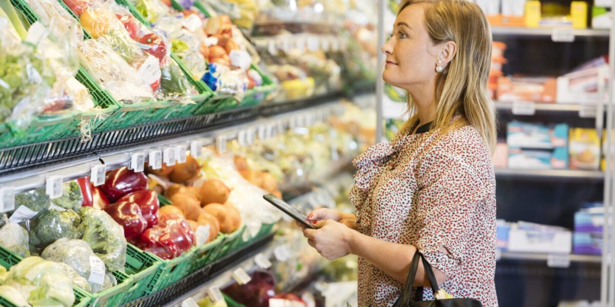 Customer,Holding,Digital,Tablet,While,Looking,At,Vegetables