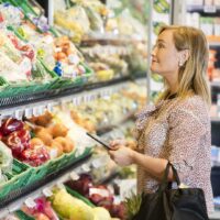 Customer,Holding,Digital,Tablet,While,Looking,At,Vegetables