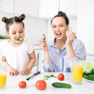 Moeder met dochter die komkommer eten krimpfolie (food) ss 1132107770