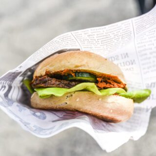 Vegetarian burger in paper, outdoor.